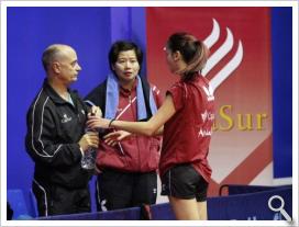 Luis Calvo dando instrucciones en el banquillo a Xi Li Guo y Marija Galonja.